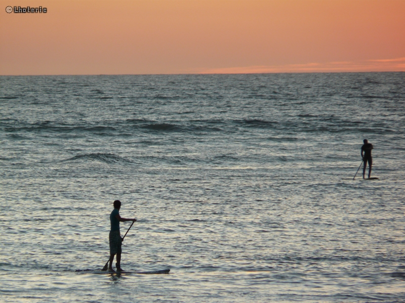 Surfeurs au soleil couchant